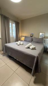 a bedroom with a large bed with two towels on it at Mare Hotel Apartment in Mar del Plata
