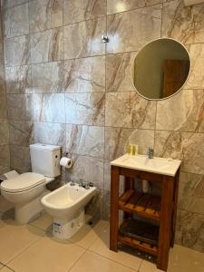 a bathroom with a toilet and a sink and a mirror at Mare Hotel Apartment in Mar del Plata +24 photos
