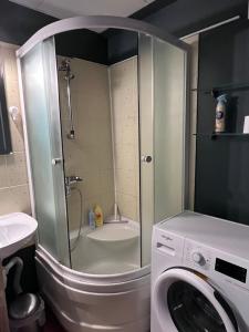 a bathroom with a washing machine and a shower at Aluksne city nest in Alūksne