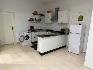 a kitchen with a white refrigerator and a washing machine at Beach house in Zarzis