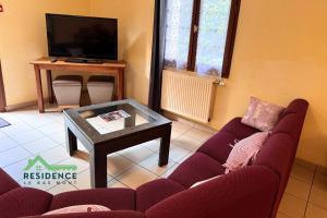 a living room with a red couch and a table at Résidence du Bas Mont in Moulay