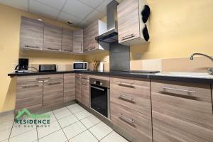 a large kitchen with wooden cabinets and appliances at Résidence du Bas Mont in Moulay