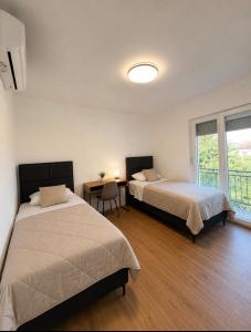 a bedroom with two beds and a table with a lamp at Panorama Krizevac in Međugorje