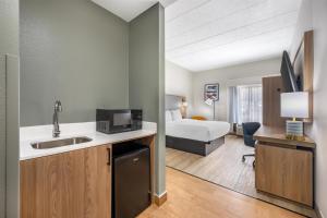 a kitchen with a sink and a room with a bed at Best Western Inn Florence in Florence