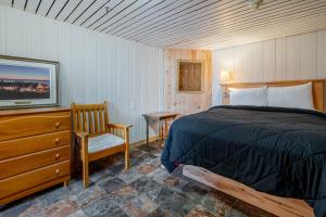 a bedroom with a bed and a tv and a chair at Manoir Charlevoix in La Malbaie +169 photos