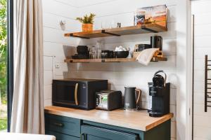 a kitchen with a counter top with a microwave at Glamping cabin with private deck and hot tub! in Guntersville