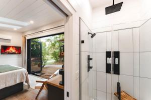 a room with a glass door leading to a bedroom at Glamping cabin with private deck and hot tub! in Guntersville