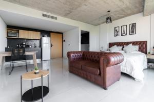 a bedroom with a couch and a bed and a kitchen at Nova Stays - Estudio con balcón al Jardín Botánico de Palermo in Buenos Aires