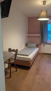 a bedroom with a bed and a table and a lamp at Hotel Zachskorn in Erdweg