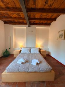 a bedroom with a large bed with two towels at Olcium Holiday Rooms in Mandello del Lario