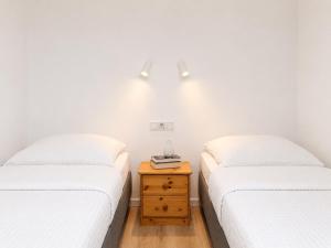 two twin beds in a room with a nightstand between them at Baltic Center Bungalows in Sarbinowo