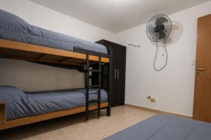 a bedroom with two bunk beds and a fan at Go Hostel in Córdoba