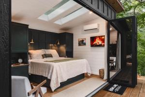 a bedroom with a bed in a room with a window at Glamping cottage with glass front and hot tub! in Guntersville
