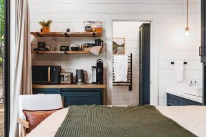 a room with a kitchen with blue cabinets and a sink at Glamping cottage with glass front and hot tub! in Guntersville