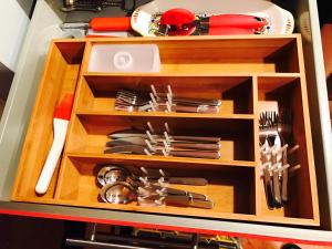 a wooden drawer with utensils in it at Studio H St Corridor in Washington, D.C.