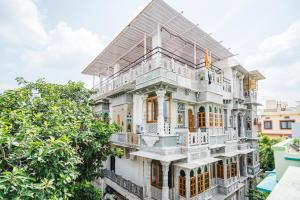 a white house with balconies and trees at Lassi Boutique Hotel in Udaipur