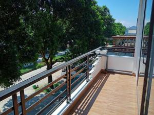 a balcony with a wooden railing and a tree at Tam coc Newway Homestay in Ninh Binh