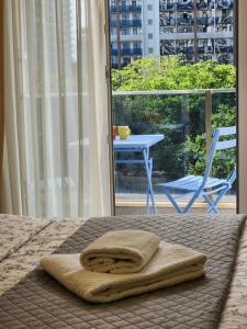 a towel on a bed with a table and a chair at Ande Tower, Batumi in Minda