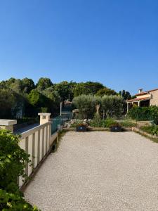 a yard with a white fence and a driveway at Appartement de vacances au 1er étage 45m2 in Antibes