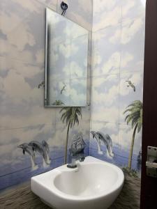 a bathroom with a sink and dolphins on the wall at Bamivigas Retreat in Kattappana +78 photos