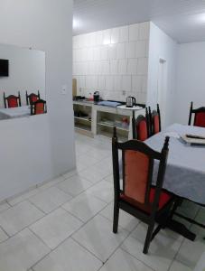 a kitchen with a table and a chair in a room at Pousada familiar 07 in Rio do Sul