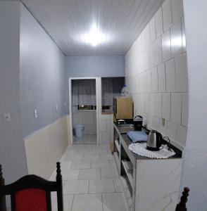 a kitchen with a counter and a stove in it at Pousada familiar 07 in Rio do Sul +2 photos