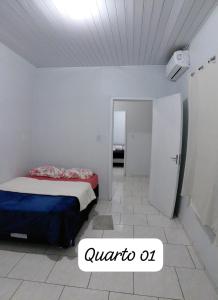 a bedroom with a bed in a white room at Pousada familiar 07 in Rio do Sul