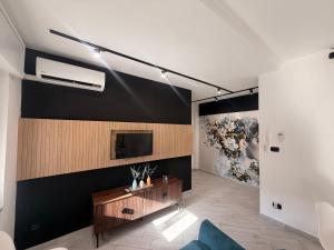 a living room with a tv on a black wall at Lo Snodo Apartments cucina e parcheggio in Pomigliano dʼArco