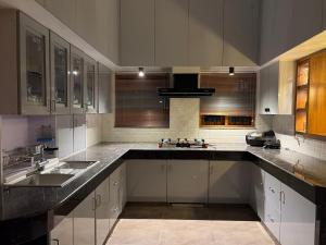 a large kitchen with white cabinets and a sink at Bamivigas Retreat in Kattappana