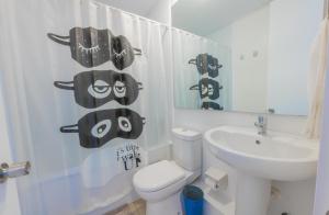 a white bathroom with a toilet and a sink at Oceana Suites Papudo in Papudo