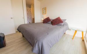 a bedroom with a large bed and a table at Oceana Suites Papudo in Papudo