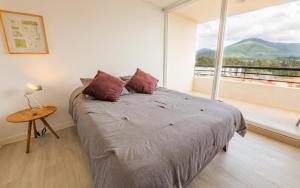 a bedroom with a bed and a large window at Oceana Suites Papudo in Papudo