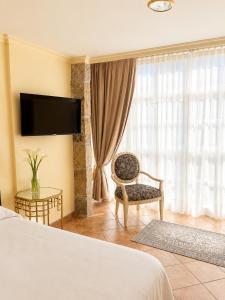 a hotel room with a bed and a chair and a window at Holibai Misiño, Estudio para dos en Baiona in Baiona