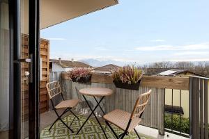 a patio with two chairs and a table on a balcony at Entre lac-montagnes et frontière in Contamine-sur-Arve
