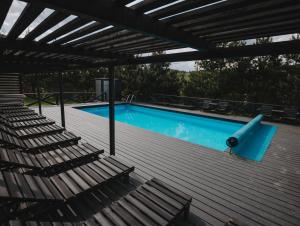 a swimming pool with chairs and a deck with a blue pool at Apart-hotel Vershina in Yaremche