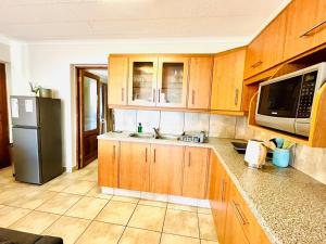 a kitchen with wooden cabinets and a stainless steel refrigerator at Lieben Gast in De Kelders