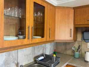 a kitchen counter with a sink and wooden cabinets at Lieben Gast in De Kelders