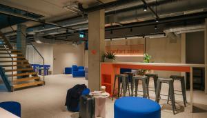 a room with blue stools and a counter with stairs at Homaris K48 Studios in Berlin