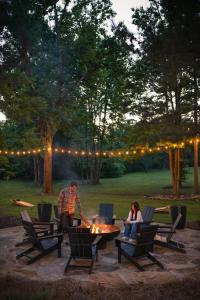 a man and a woman sitting around a table at Luxury tiny cottage with deck hammock and hot tub! in Guntersville +4 photos