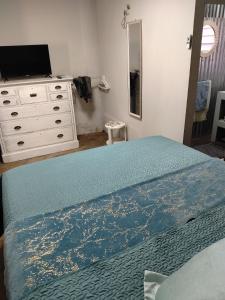 a bedroom with a bed and a dresser at Avalon Cottages in Barberton