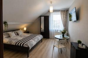 a bedroom with a bed and a table and a window at Szept Fal & Minigolf in Rewal