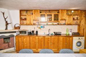a kitchen with wooden cabinets and a stove at Вила Якимови in Ribarica