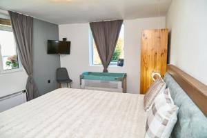 a bedroom with a bed and a chair and a television at Вила Якимови in Ribarica +20 photos