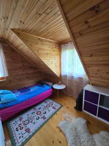a room with a bunk bed in a wooden house at Urokliwy domek Młynarze in Młynarze