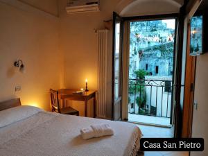 a bedroom with a bed and a window with a table at Cave Rooms Sassi in Matera