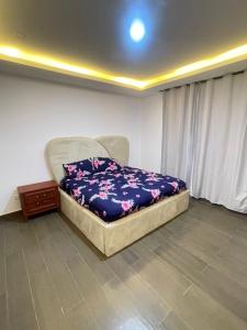 a bedroom with a bed with a blue blanket on it at Maisonette near Alpha Beach in Ibeju