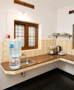 a kitchen with a sink with a bottle of water on the counter at GOOD KARMA INN Apartment in Cochin