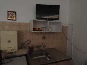 a kitchen with a sink and a tv on the wall at Стая за гости При Валко in Belogradchik