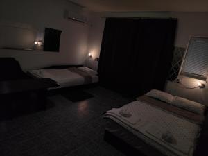 a dark room with two beds and two lights at Стая за гости При Валко in Belogradchik