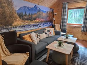 a living room with a couch and two tables at Chata Pod Dlhou veľká Podbanské in Pribylina